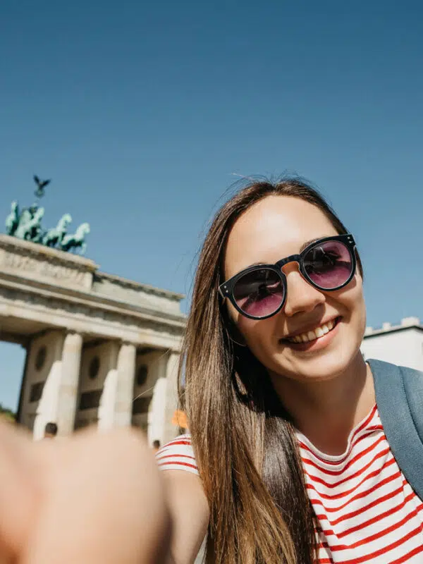 A student taking a selfie with the Brandenburg gate on a school trip to Germany