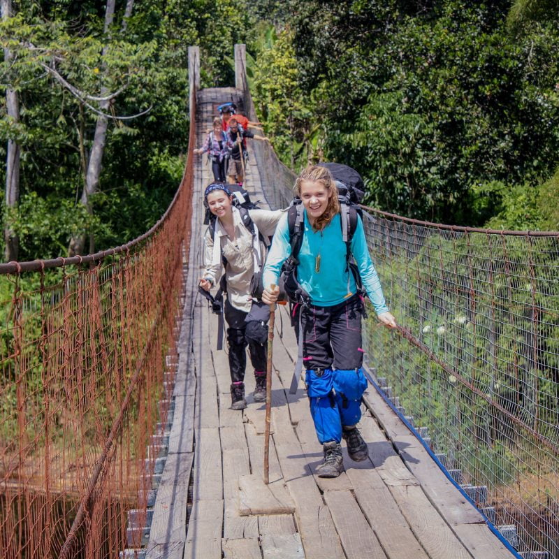Students hiking across a suspension bridge