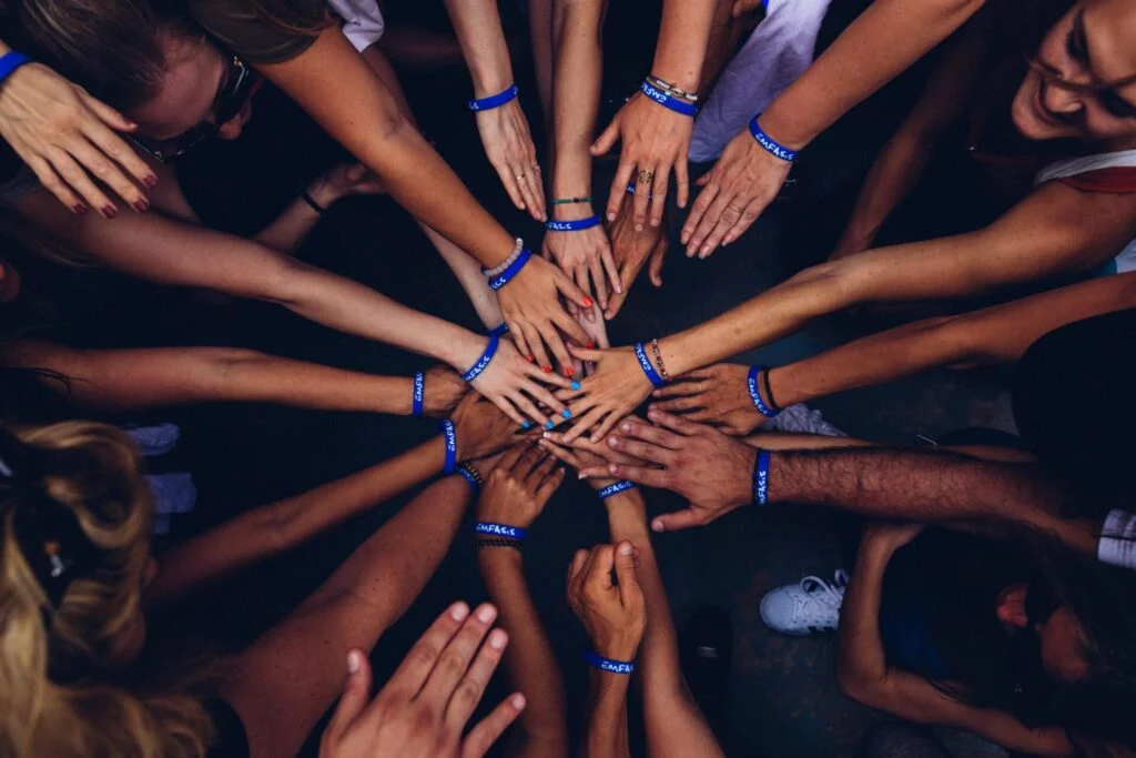 A school group putting their hands together in a circle