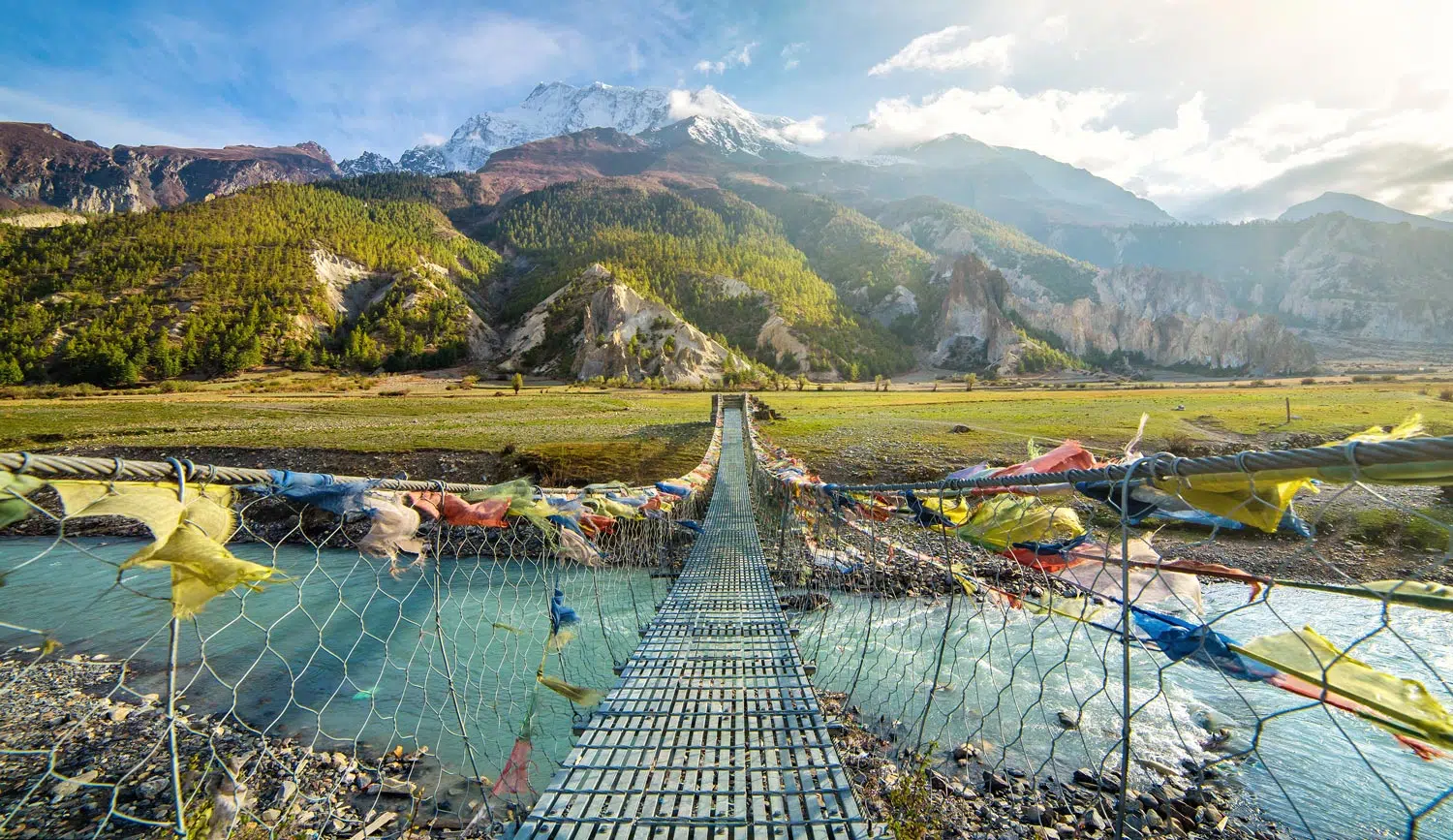 A suspension bridge over a river in the mountains of Nepal on a school expedition